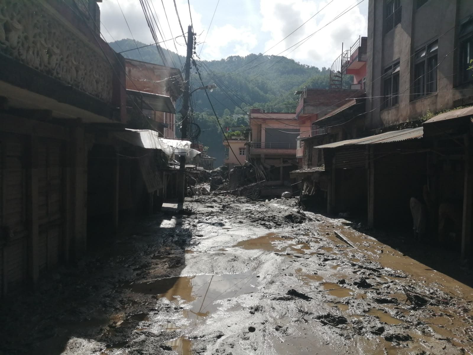 Submerged village street in deep mud and flood silt